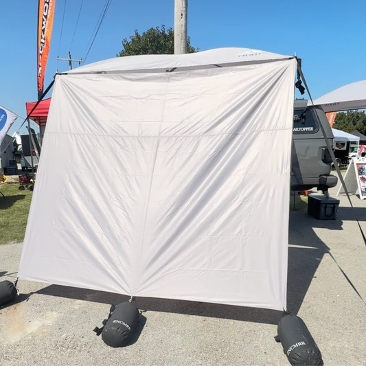 Trail Topper awning 8x7 side wall set up outdoors with visible branding on a clear day.