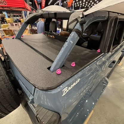 Back of a Ford Bronco with a JFTops Rhino lined cargo cover at an indoor event.