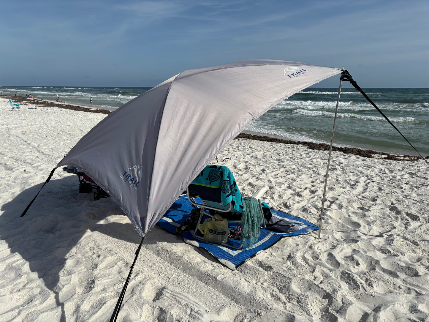 Beach set up with Trail Topper X-Large portable awning on a sandy beach with ocean view
