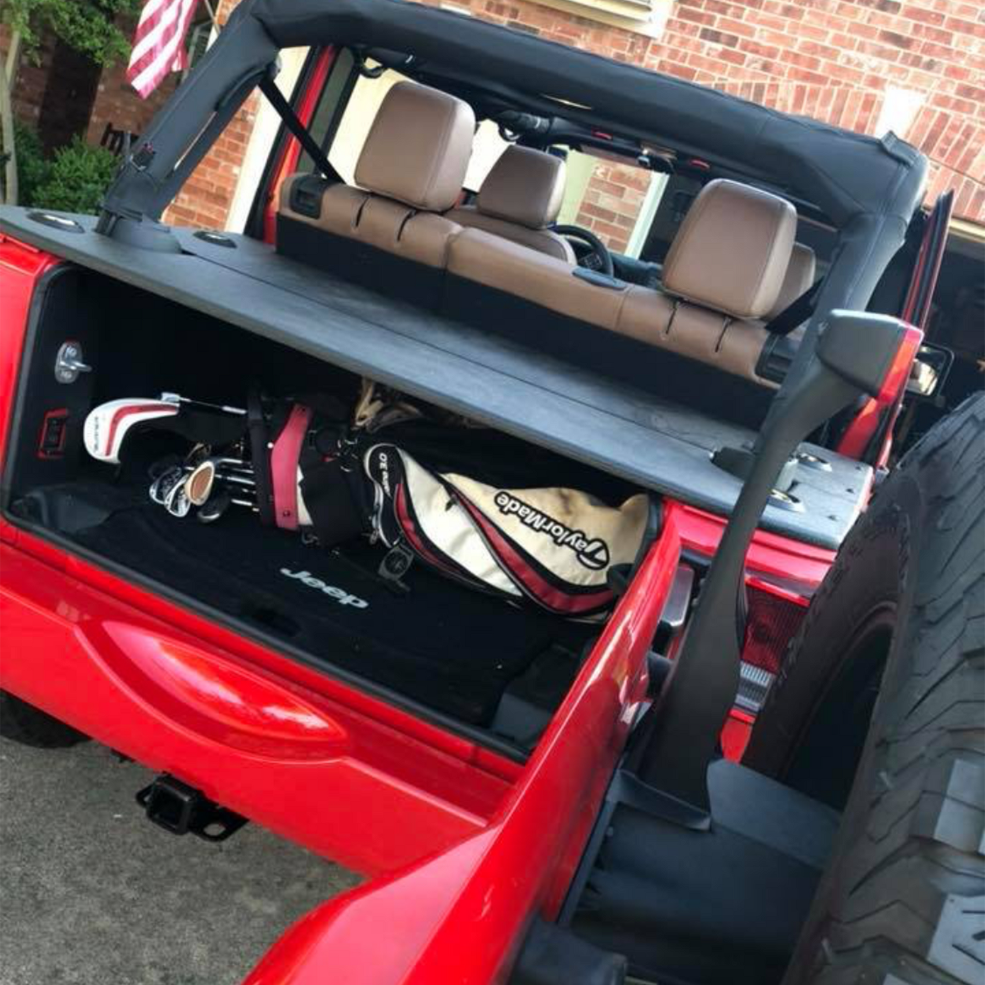 JFTops JKU Rhino Lined Cargo Cover on red Jeep with golf clubs in back and open trunk