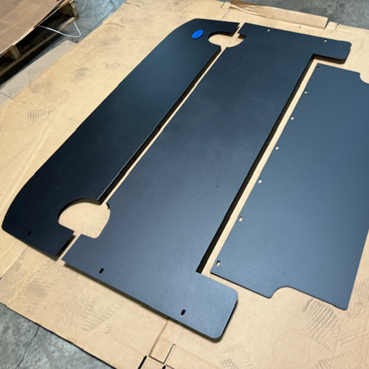 3 piece cargo cover in aluminum layed out on cardboard for full view 