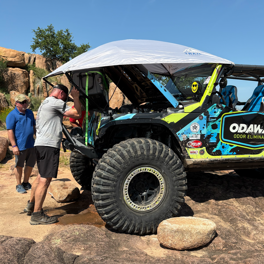 Off-road vehicle with Trail Topper shading men working on a Jeep
