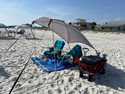 Beach setup with chairs, X-large shade awning, cooler, and cart on sandy beach.