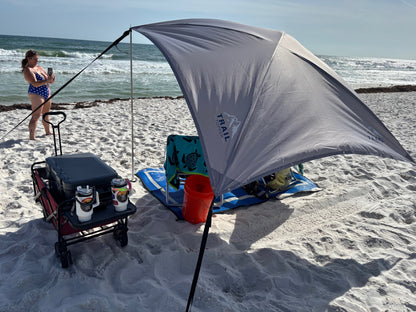Trail Topper Overland awning set up on a sandy beach with a person in the background.