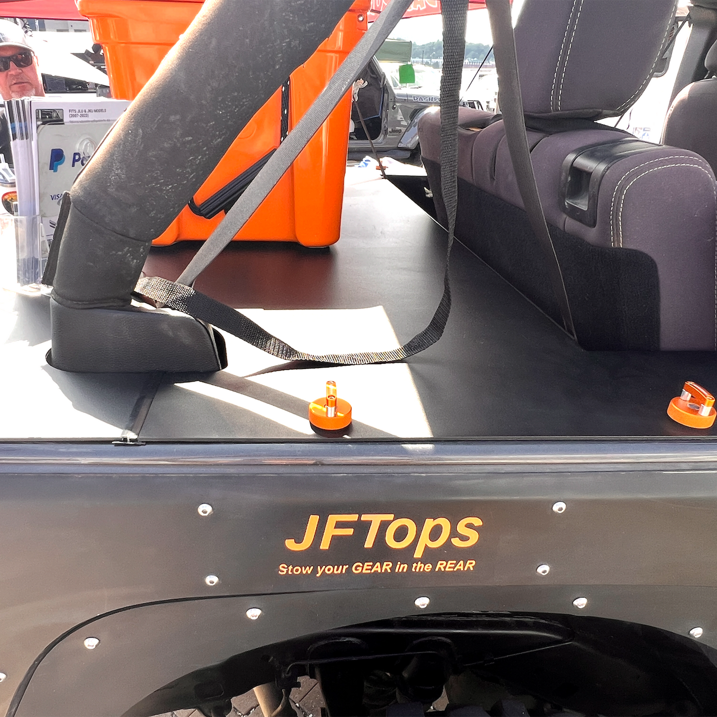 JFTops JKU Wrangler Jeep cargo cover with an orange cooler in the background and Rockworkx orange hard top thumbscrews